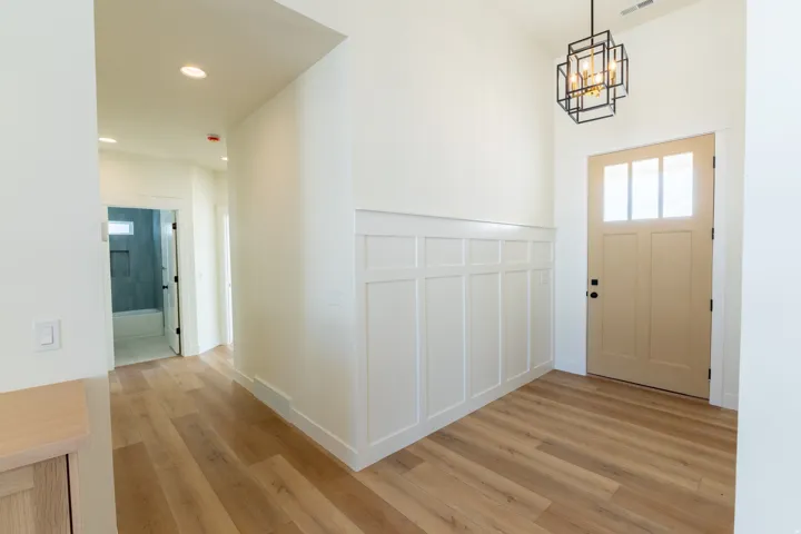 Entryway featuring wood-finish flooring, wainscoting, recessed lighting, and a modern geometric pendant light