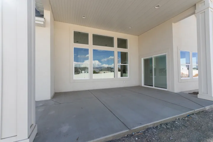 Expansive covered patio with concrete slab flooring and recessed lighting