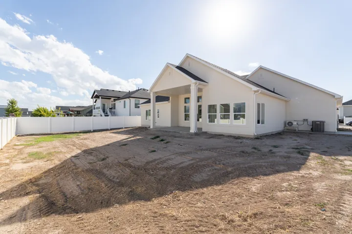 White stucco exterior with a covered patio and multiple large windows