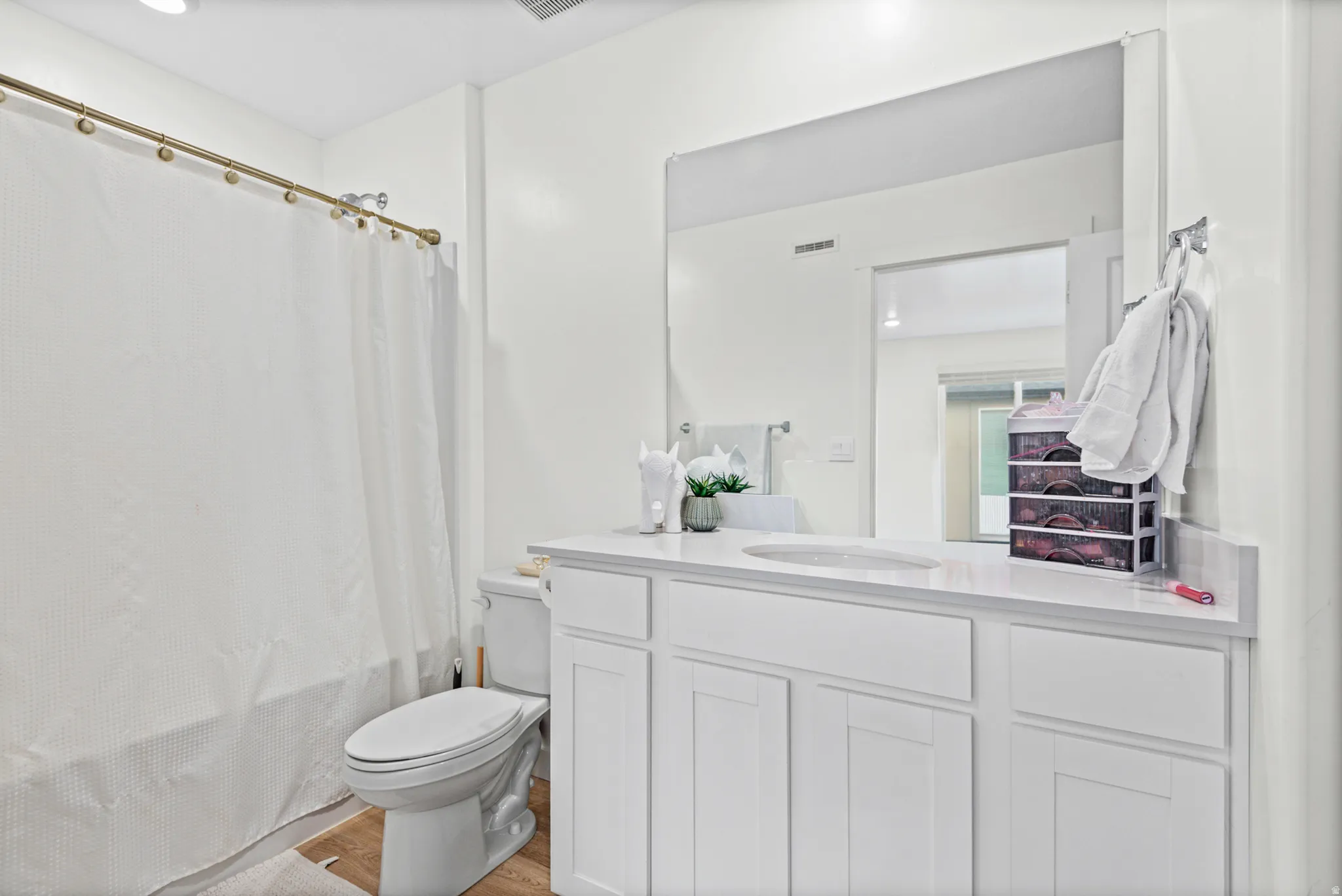 White vanity with a solid surface countertop and undermount sink