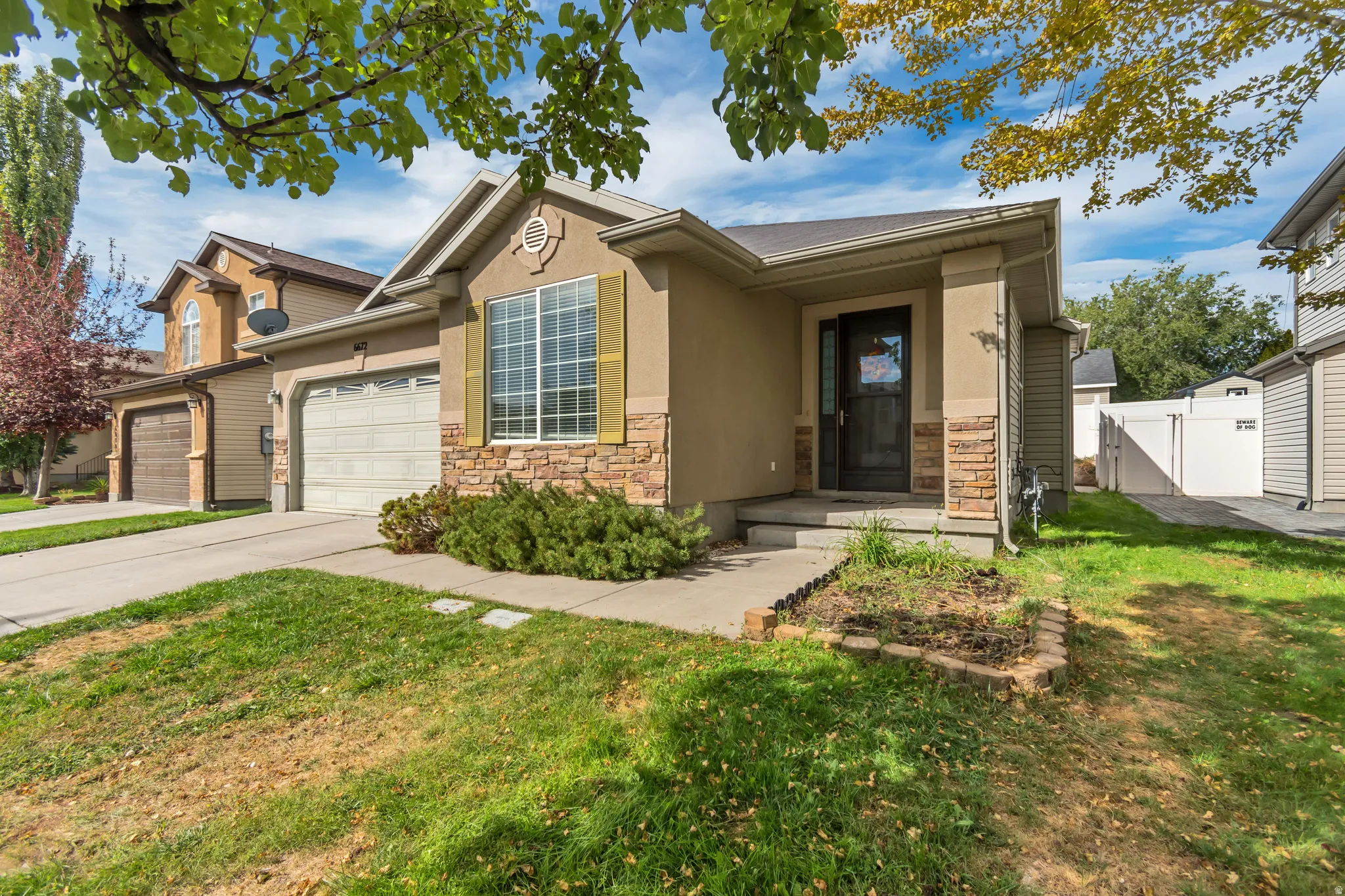 Exterior featuring a stucco finish, stone veneer accents, and a covered entry
