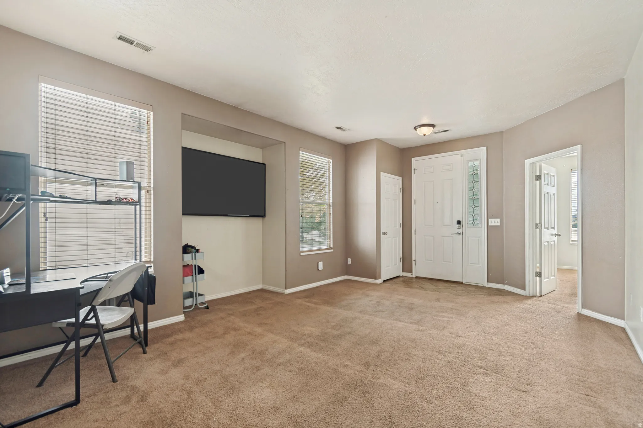 Expansive living area featuring neutral carpeting and wall tones