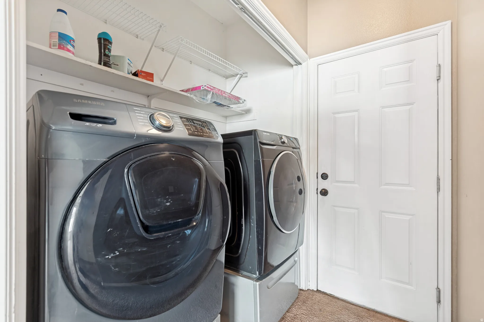Laundry area featuring a paneled door, built-in shelving, and a neutral wall color