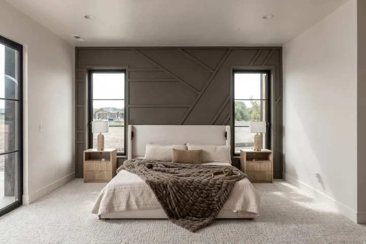 Textured accent wall, recessed ceiling lighting, full-height windows, and light-toned carpet