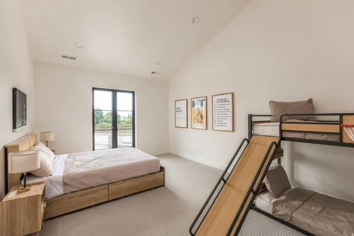 Vaulted ceiling with recessed lighting, large double-pane windows, light-toned carpeting, and light-toned walls
