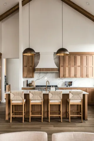 Vaulted ceiling with exposed wood beams, wood-finish flooring, island with integrated seating, white countertops, and wood cabinetry