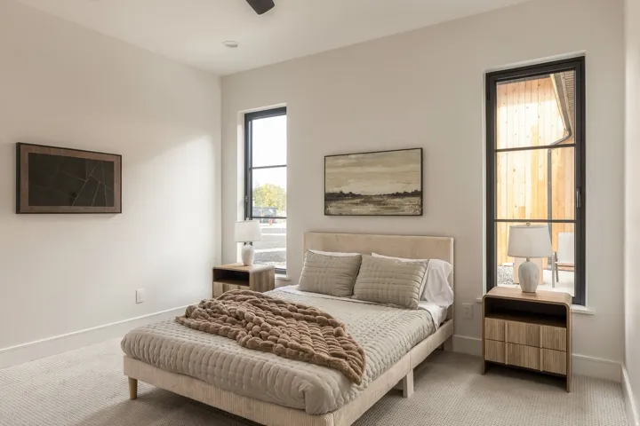 Recessed lighting illuminates the room with light-toned carpeting and substantial baseboards