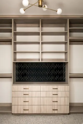 Custom built-in cabinetry with extensive shelving, integrated drawers, and a decorative back panel