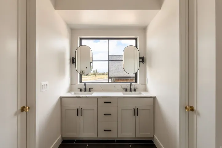 Dual vanities with undermount sinks, stone countertops, and matte black fixtures