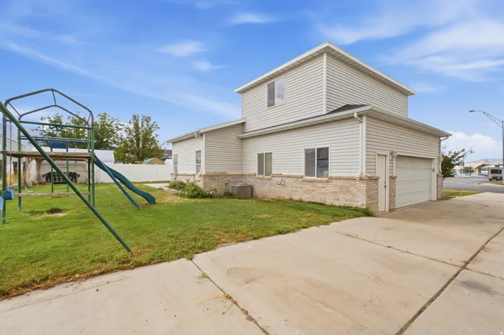 Two-story exterior with siding and brick accents, attached garage, and a concrete driveway