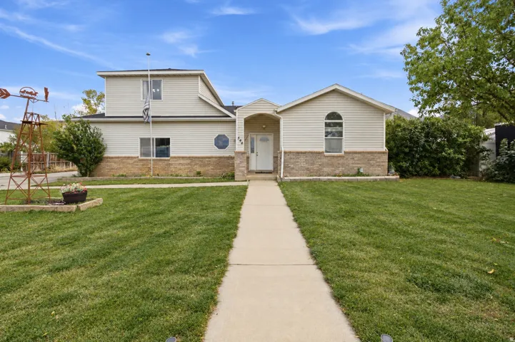 Siding exterior with brick wainscoting, arched entry, arched window, and circular window detail