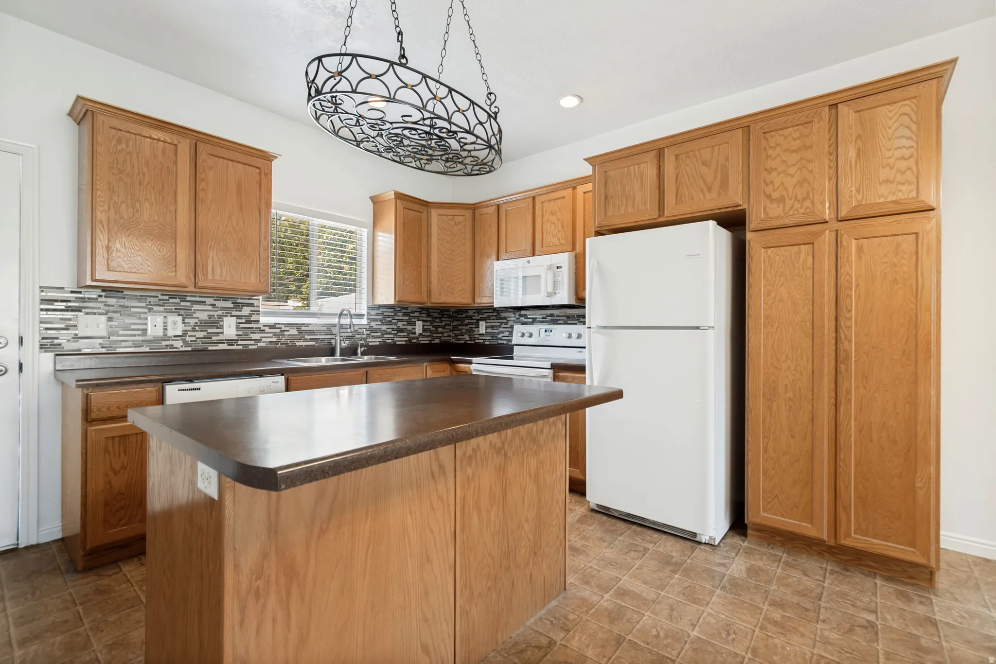 Kitchen featuring wood cabinetry, an eat-at island, and a mosaic tile backsplash