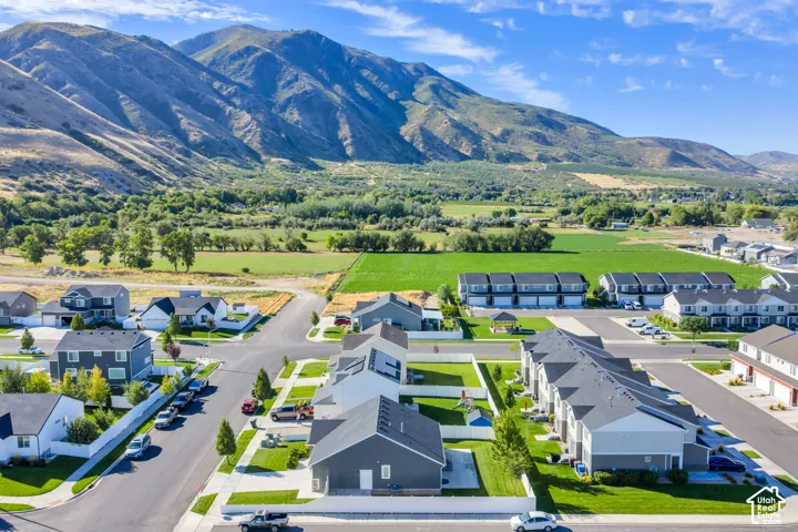 Aerial perspective showcasing the community with varied architectural styles, manicured lawns, green spaces, and mountain scenery