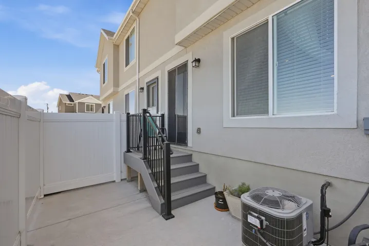 Private patio with concrete flooring, white vinyl fencing, and direct exterior access
