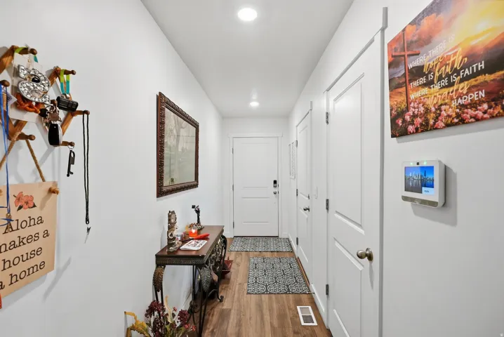 White interior walls, recessed ceiling lighting, wood-finish flooring, and white interior doors