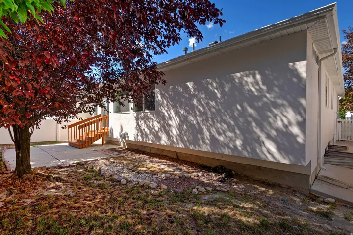 Stucco exterior with a concrete patio and wood deck stairs
