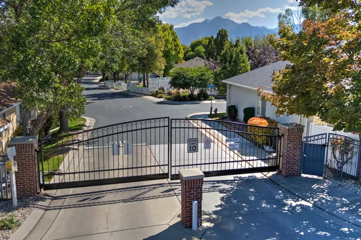Gated community entry with brick columns and wrought iron gates