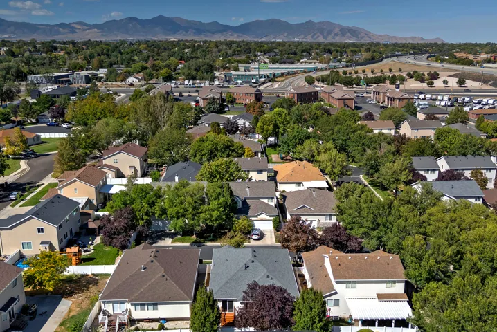 Extensive residential area with established landscaping, multiple residential structures, and distant mountains