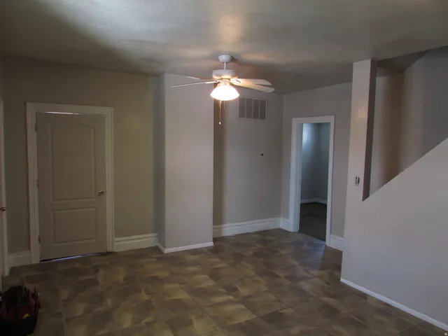 Patterned tile-finish flooring, light-toned wall paint, white trim, and ceiling fan with integrated lighting