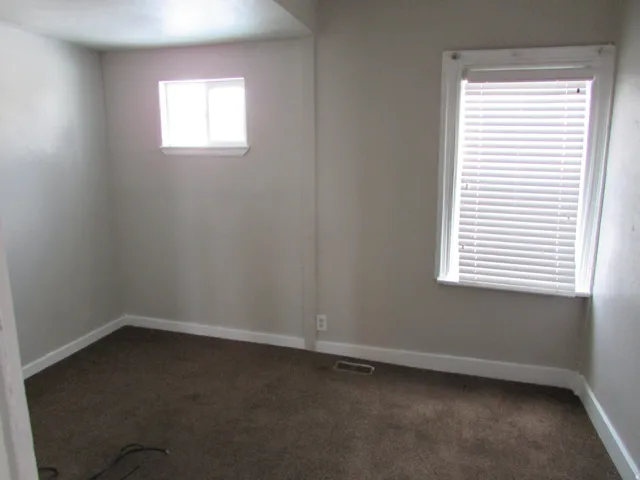 Neutral-toned walls complement the brown carpet flooring