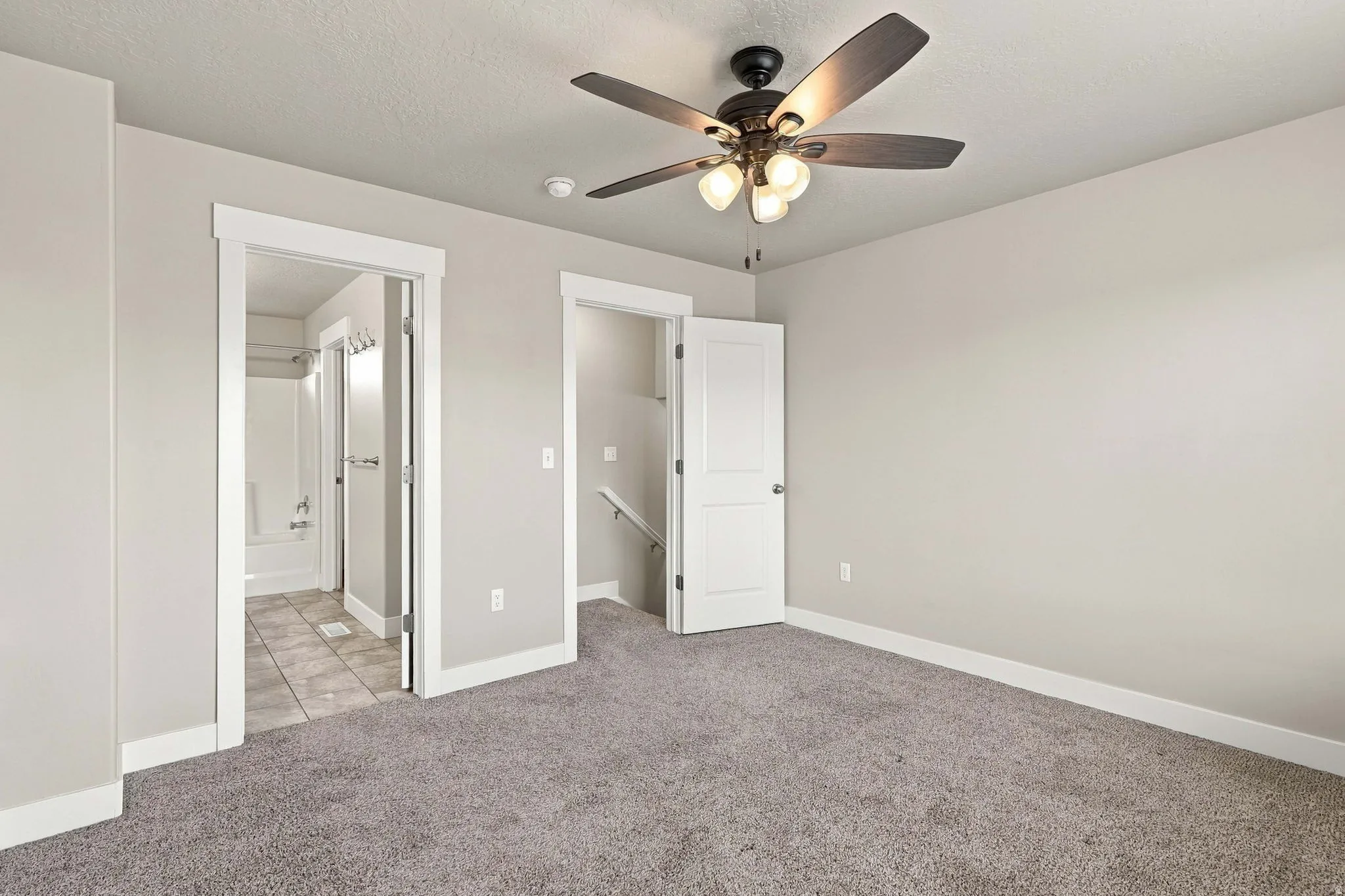 Neutral wall paint, ceiling fan with integrated lighting, carpet flooring, and white trim