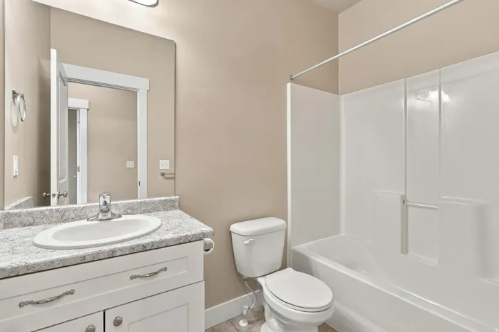 White vanity with a stone-look countertop and integral sink