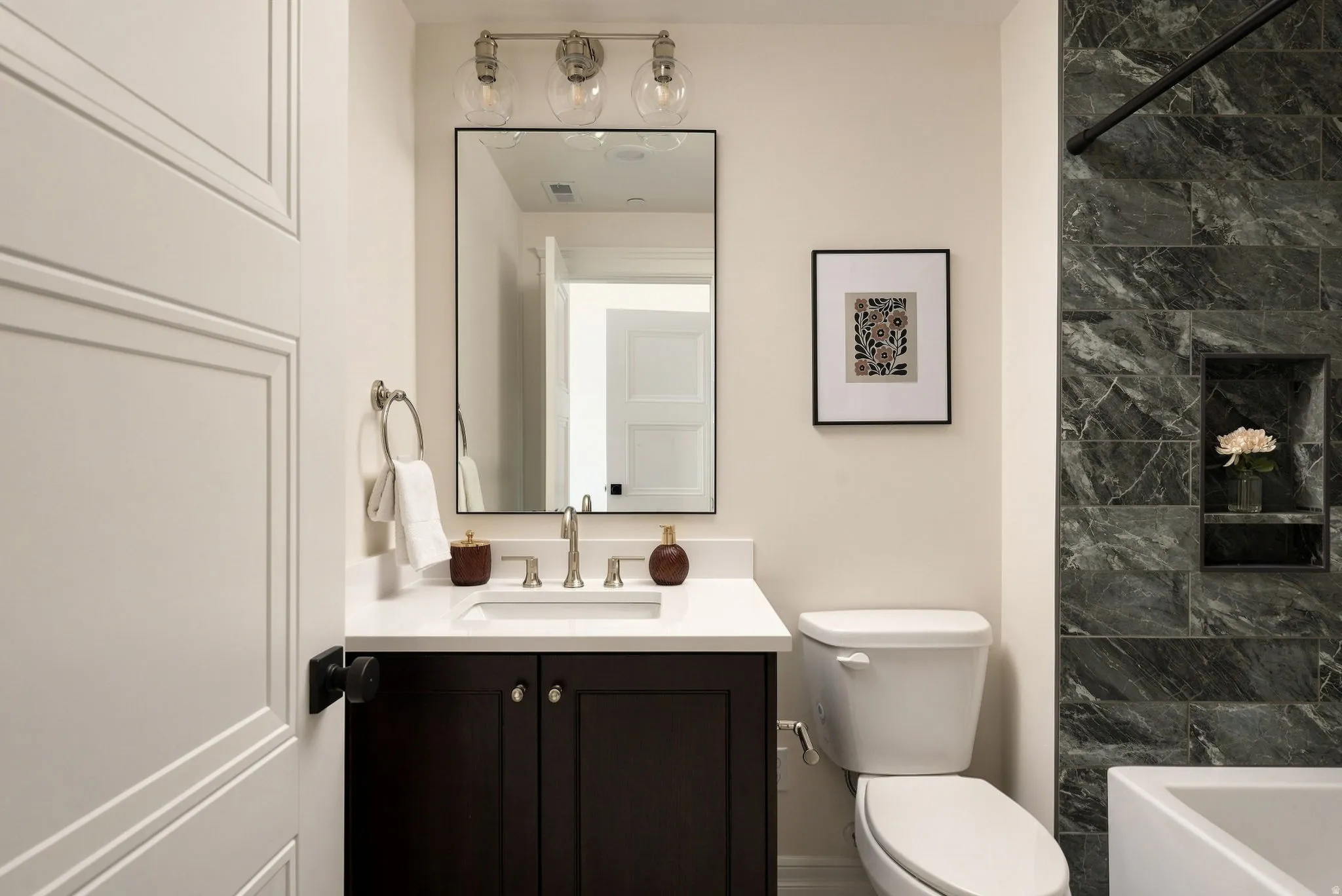 Dark wood-finish vanity with a white countertop and undermount sink