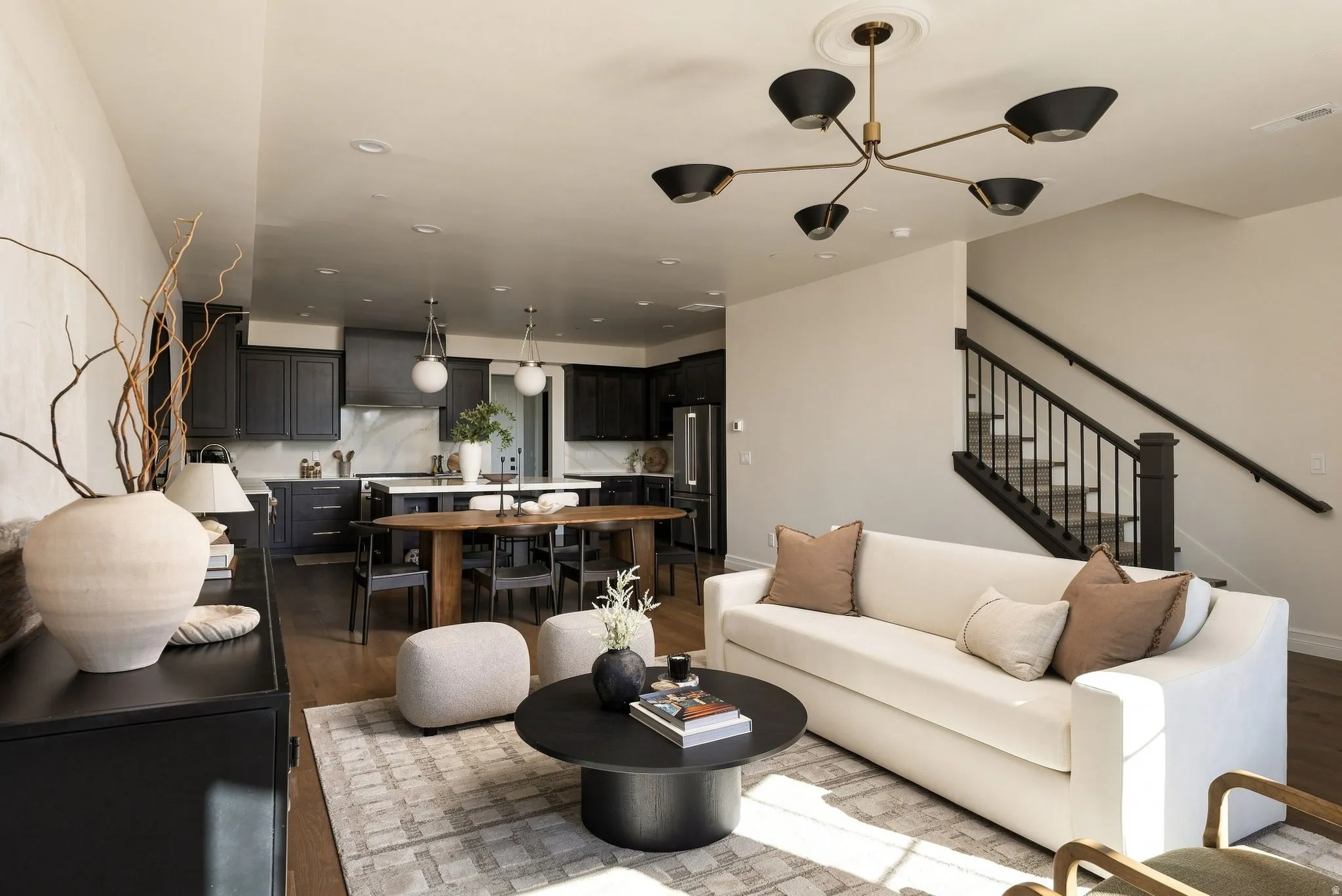 Open-concept living area featuring wood-finish flooring and a contemporary chandelier