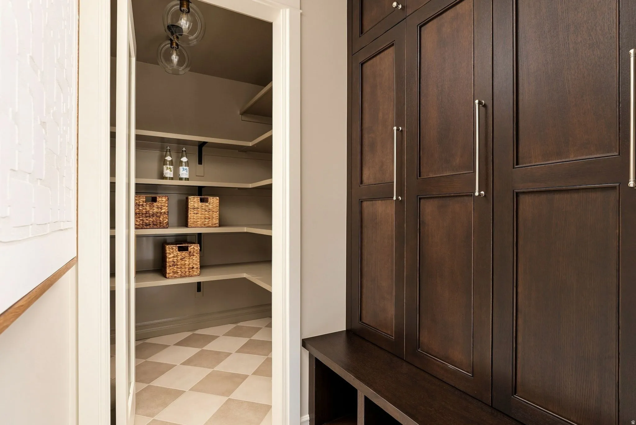 Built-in dark wood cabinetry with silver-tone hardware, providing storage and an integrated bench