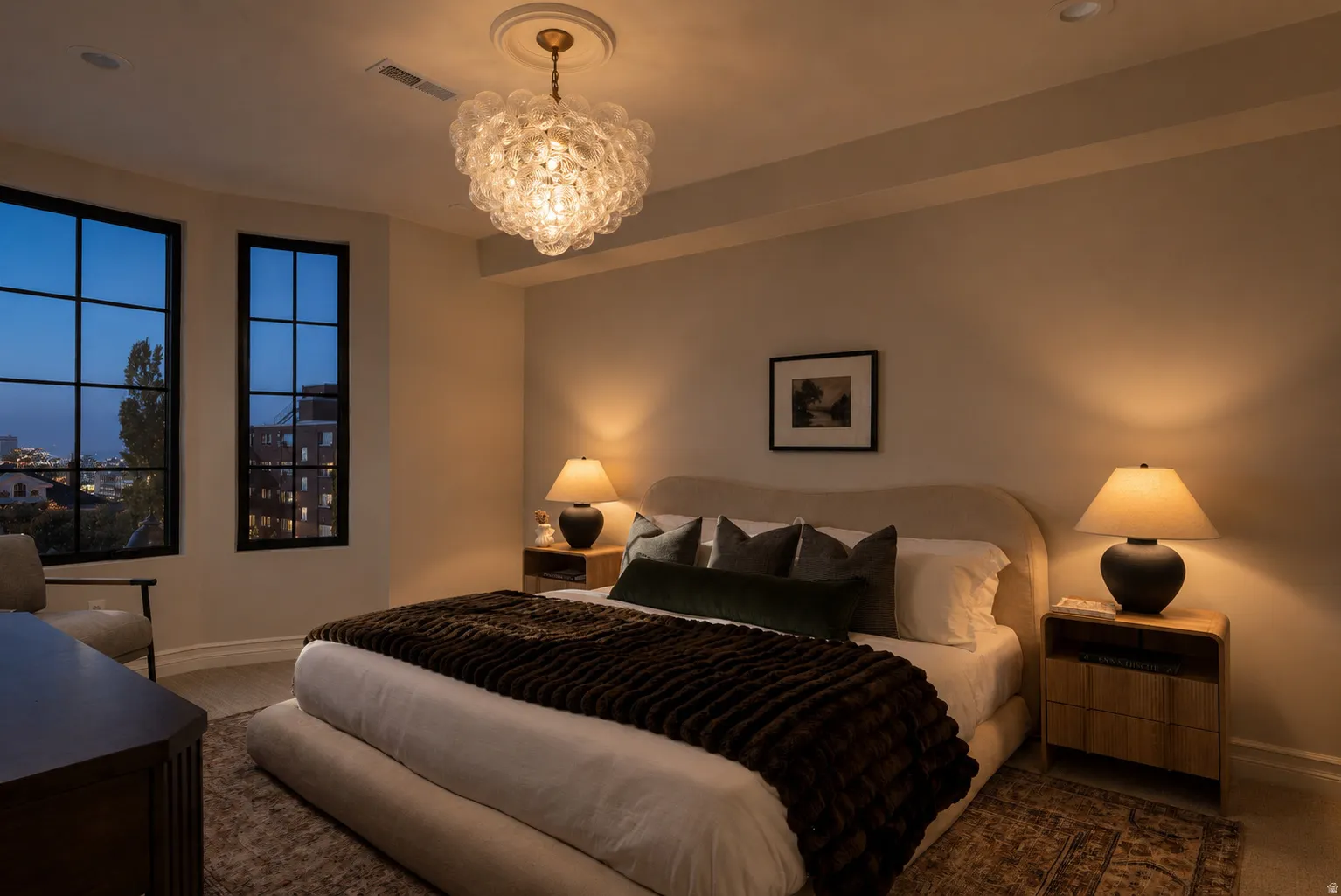 Arched windows with dark mullions, ornate ceiling light fixture, recessed ceiling lighting, light-toned wall paint, and wood-finish nightstands
