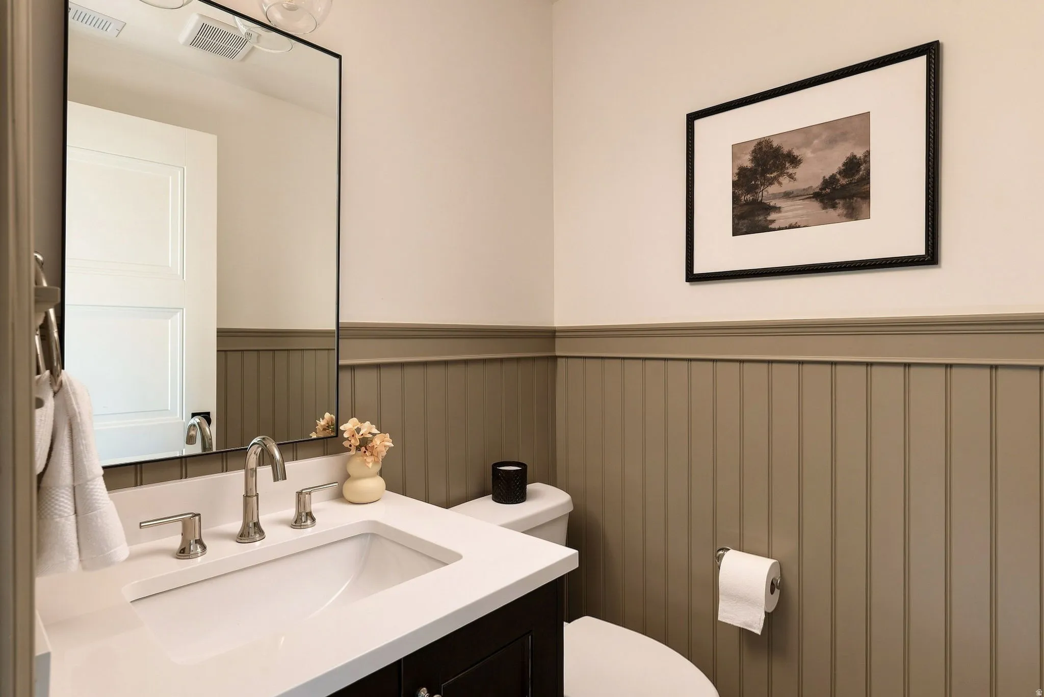 Built-in vanity with a rectangular undermount sink, brushed nickel faucet, and white countertop