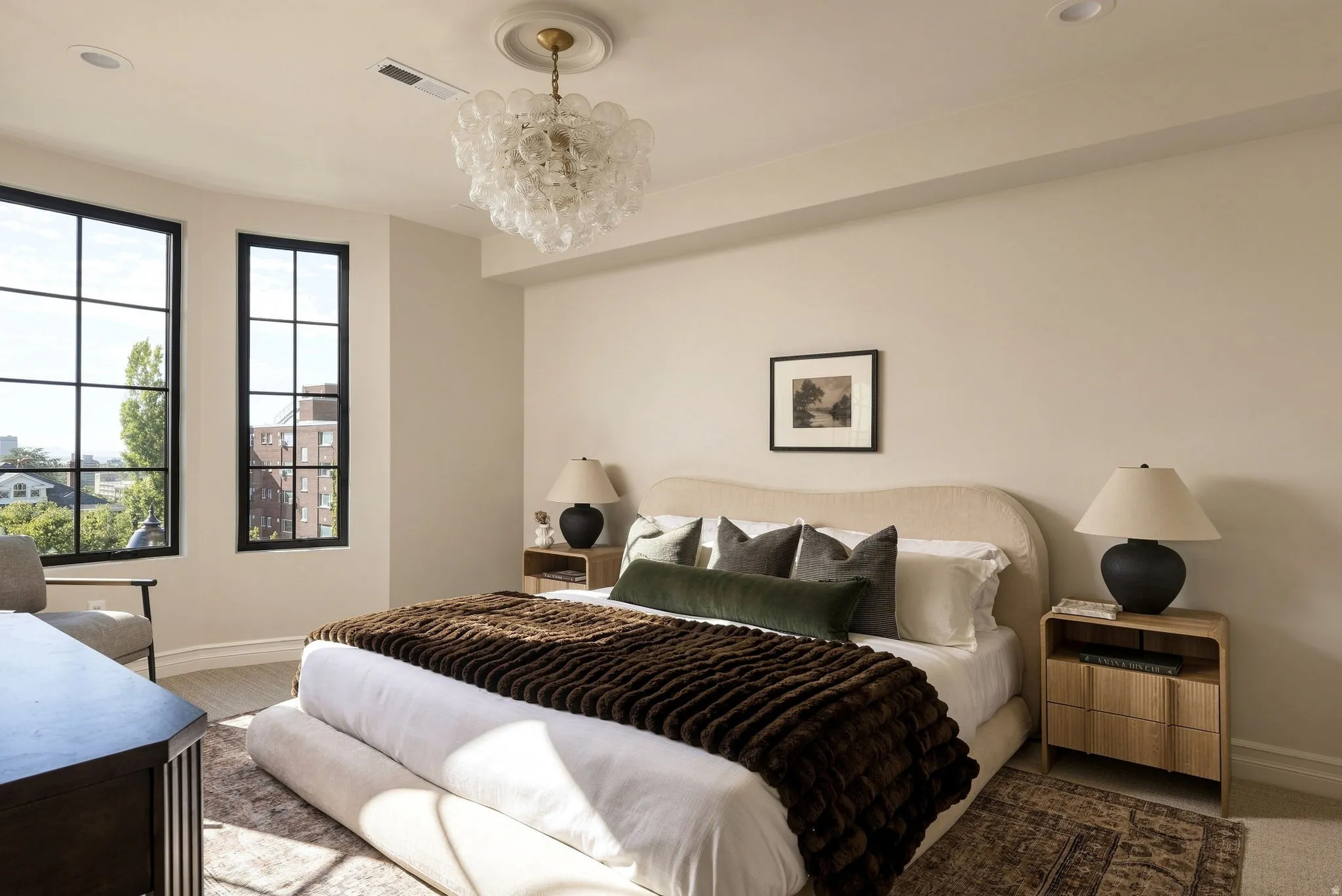 Recessed lighting, elegant chandelier, light-toned walls, and wood-finish flooring