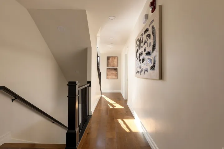 Hardwood flooring, recessed lighting, and a dark wood banister