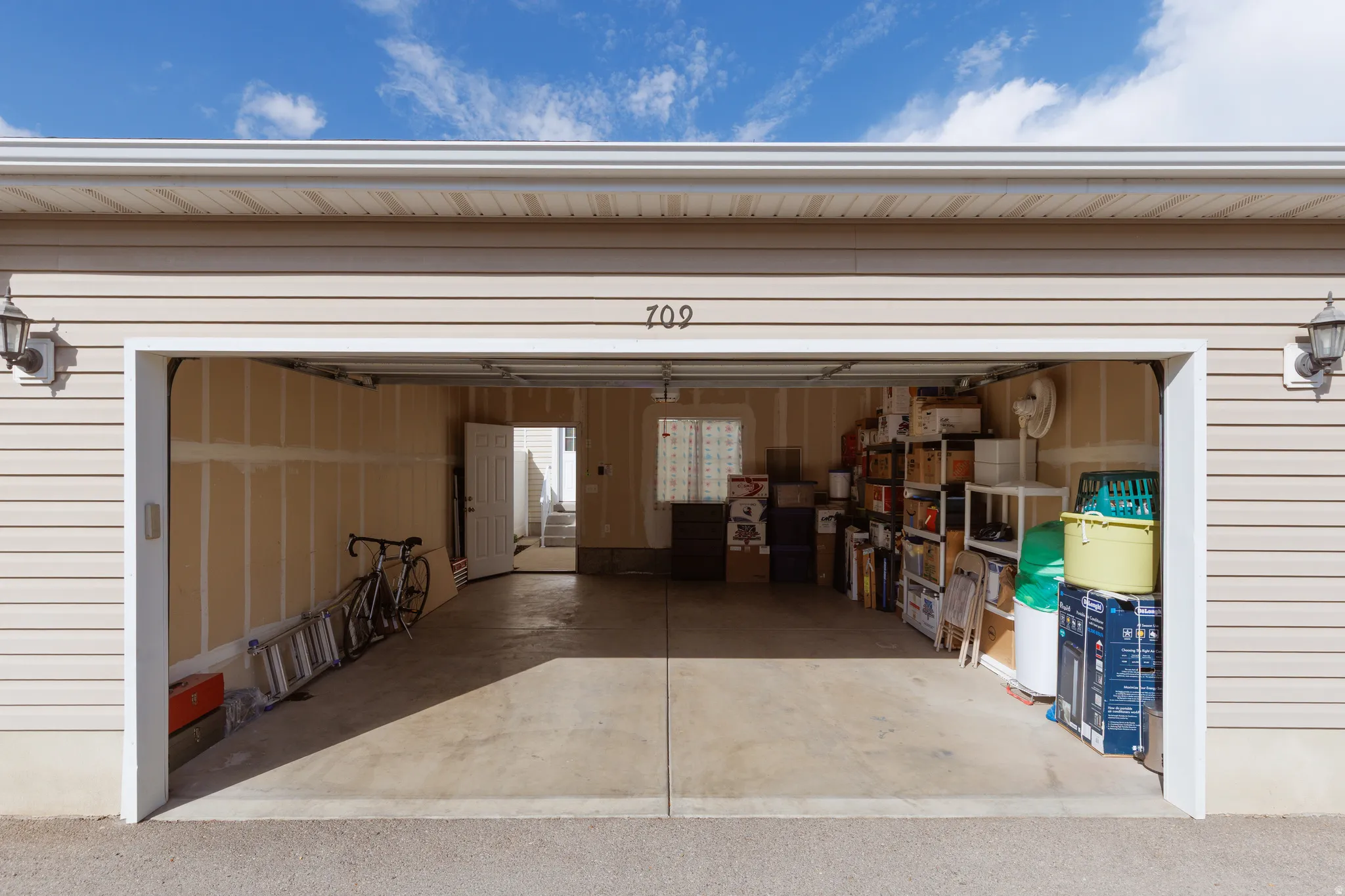 Two-car garage with concrete flooring, overhead garage door, and interior access door
