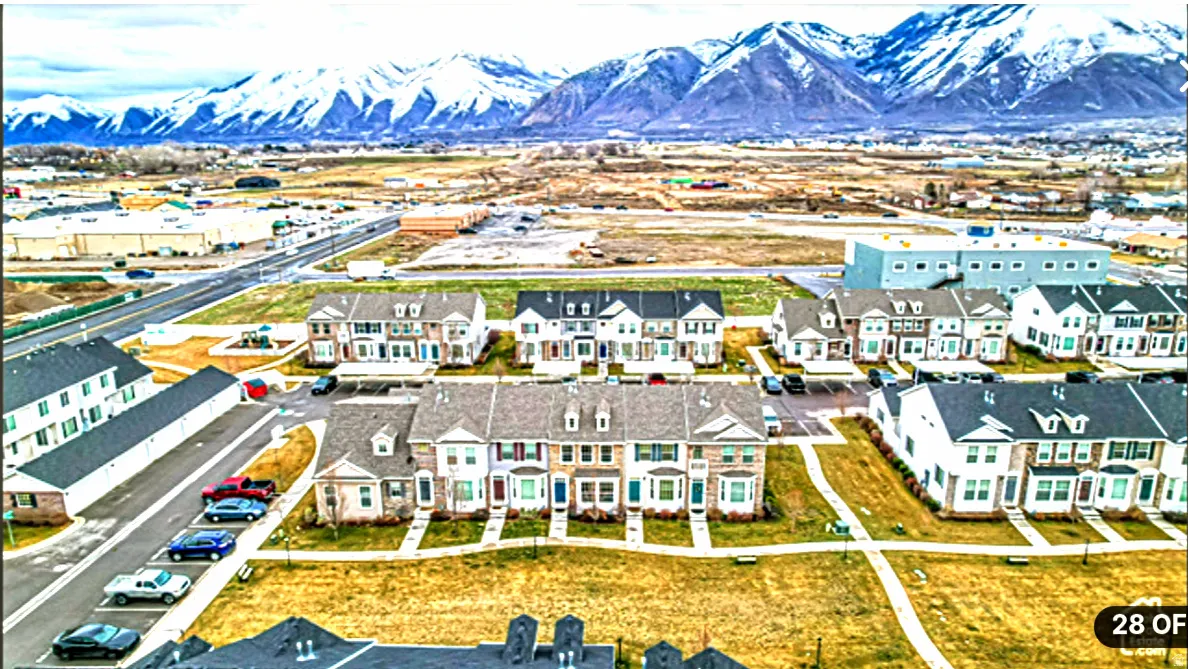 Aerial perspective of a residential community with snow-capped mountains in the background