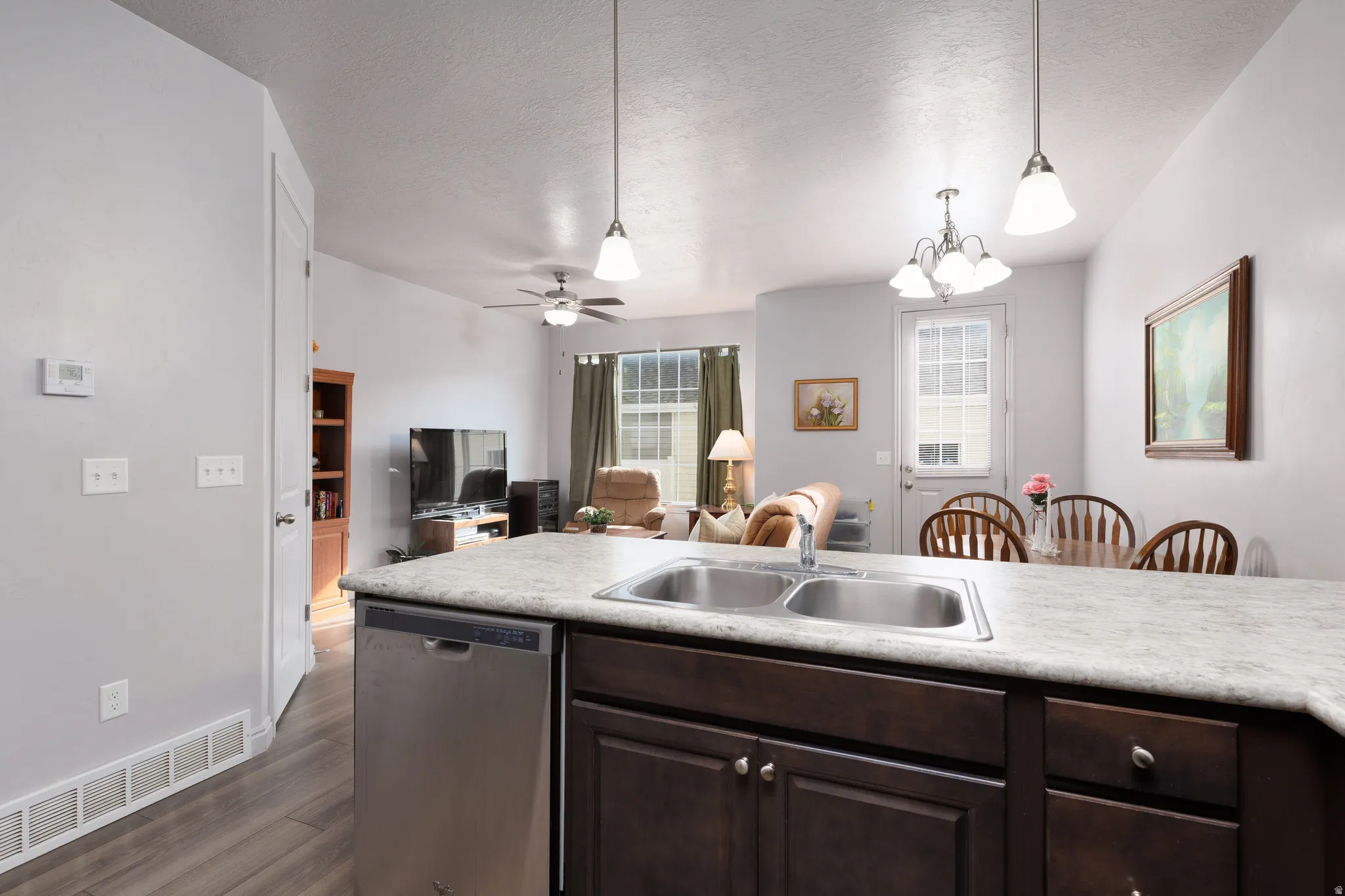 Spacious kitchen island with double basin sink, integrated dishwasher, and dark wood-finish cabinetry
