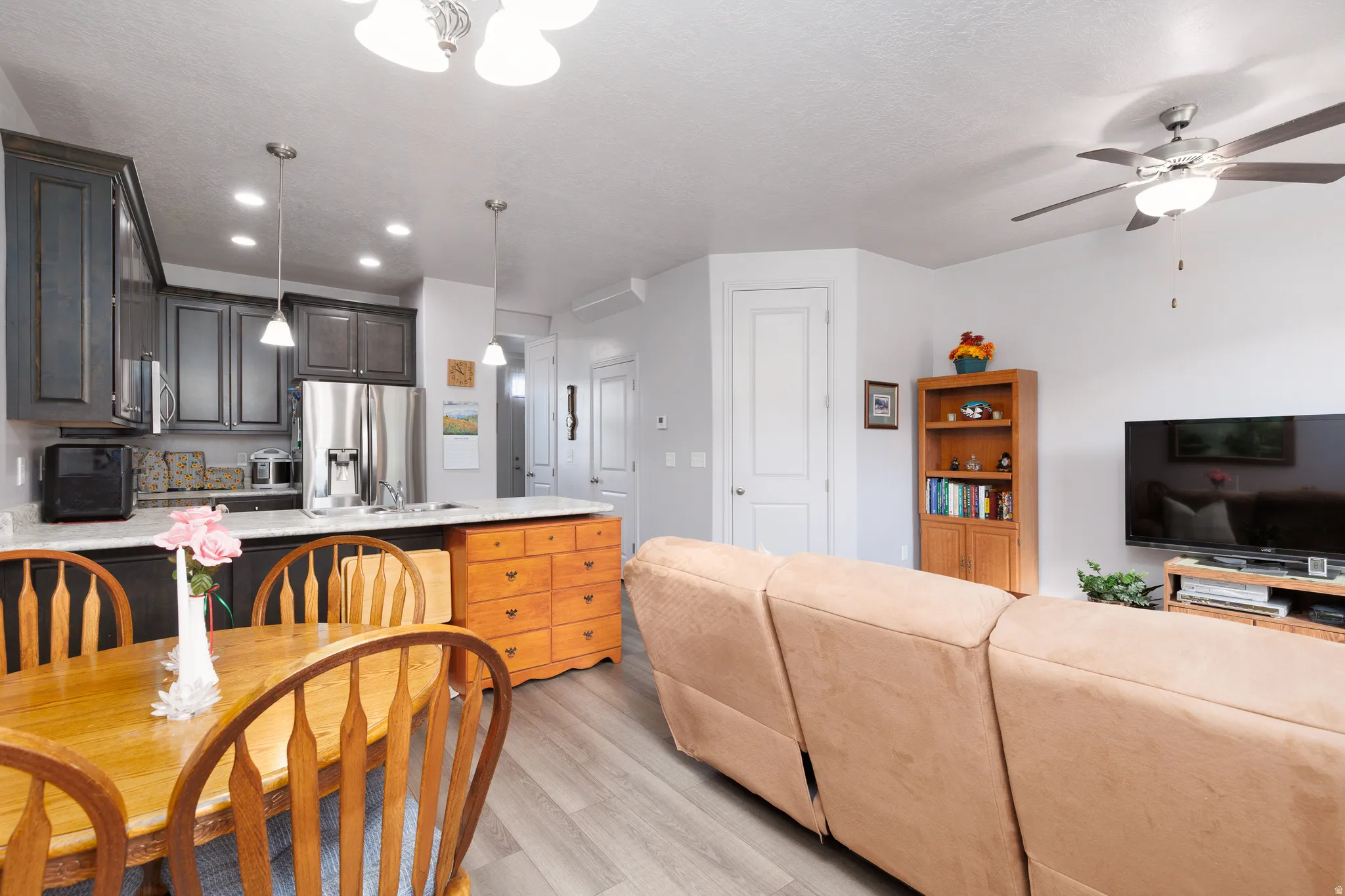 Kitchen featuring dark cabinetry, stainless steel appliances, and pendant lighting