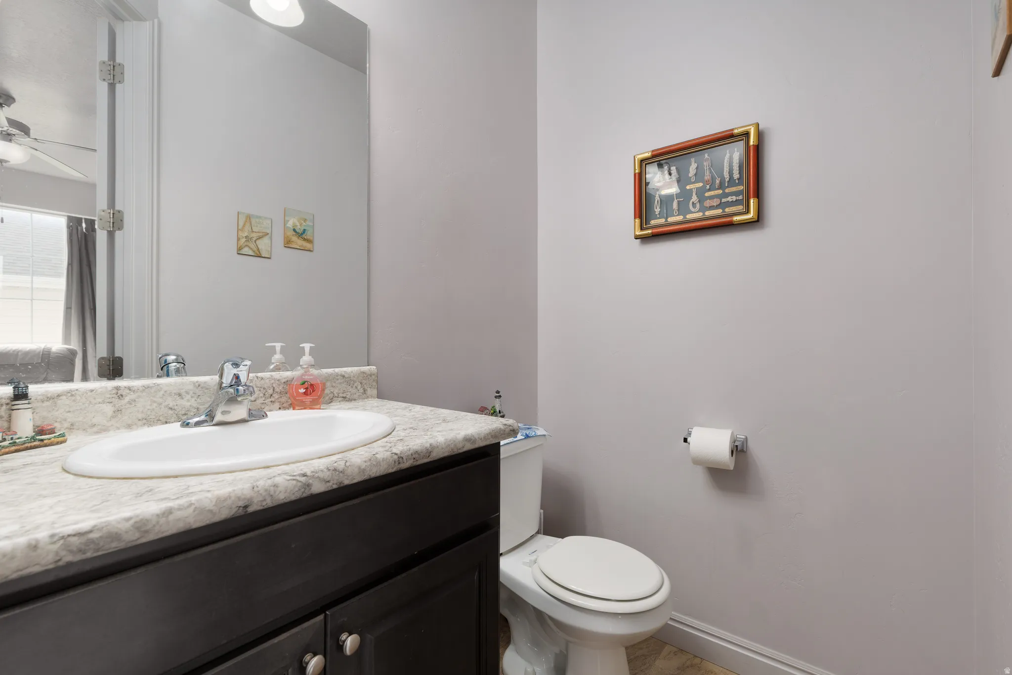 White oval sink with chrome faucet, set into a speckled countertop