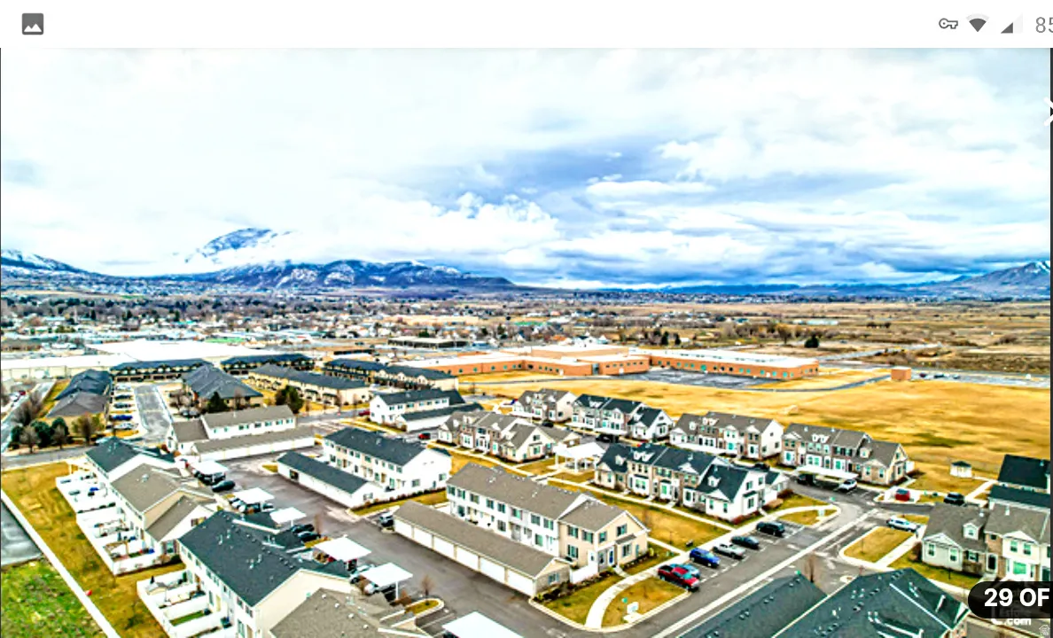 Residential community with varying architectural styles, paved roadways, and a backdrop of distant mountains