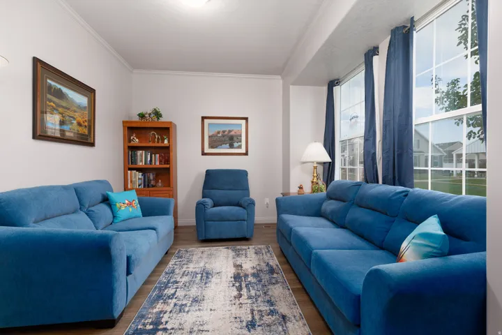 Bright living area featuring wood-finish flooring, white walls, and prominent window with natural light