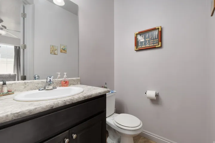 White oval sink with chrome faucet, set into a speckled countertop