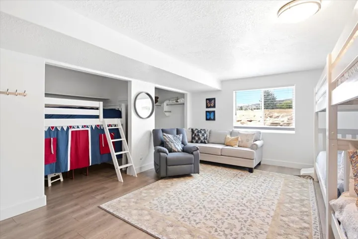 Recessed lighting, wood-finish flooring, and a large window with natural light