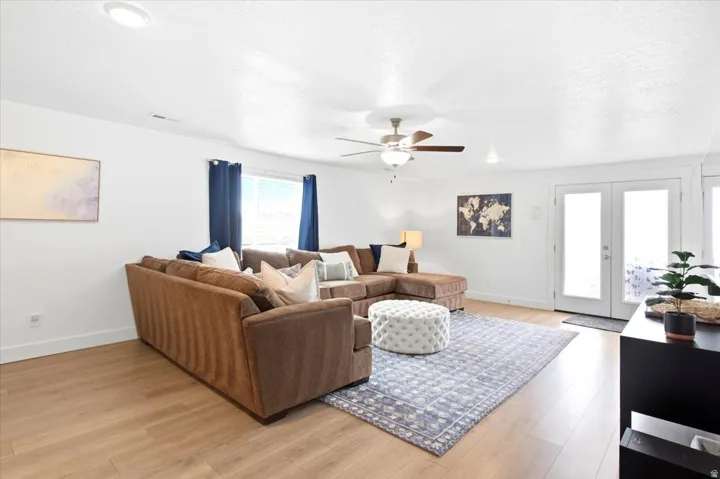 Recessed lighting, wood-finish flooring, ceiling fan with light fixture, and white double French doors