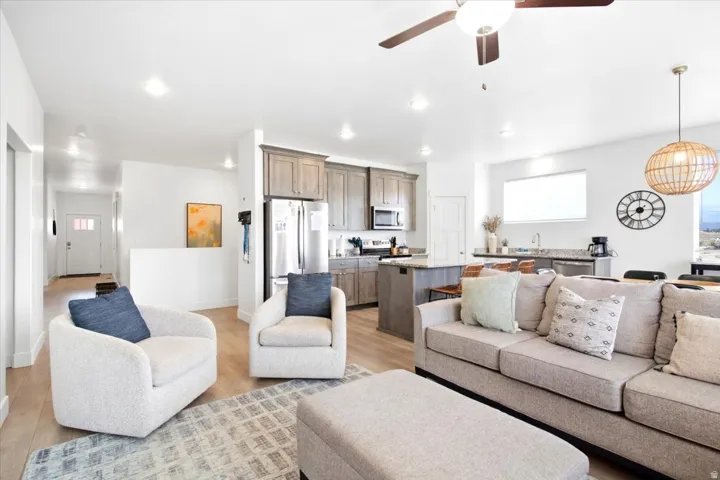 Open concept living area with wood-finish flooring, recessed lighting, and a ceiling fan
