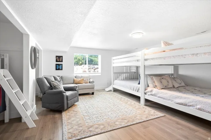 Spacious room with wood-finish flooring, white walls, and recessed lighting