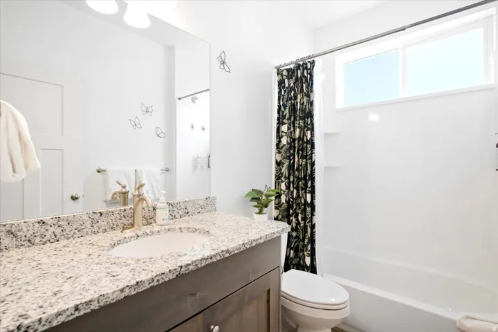 Vanity with a granite countertop, undermount sink, and a single-handle faucet