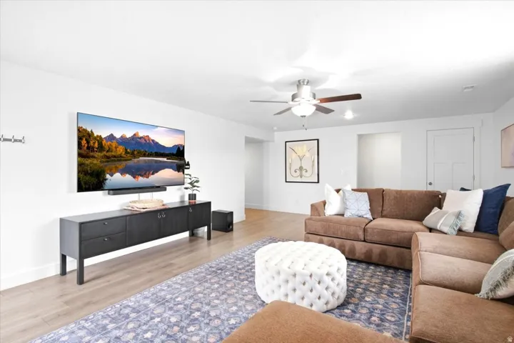 Recessed lighting, wood-finish flooring, and a ceiling fan with integrated lighting