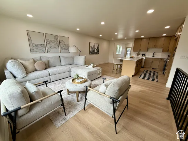 Recessed lighting illuminates the open-concept living space with wood-finish flooring