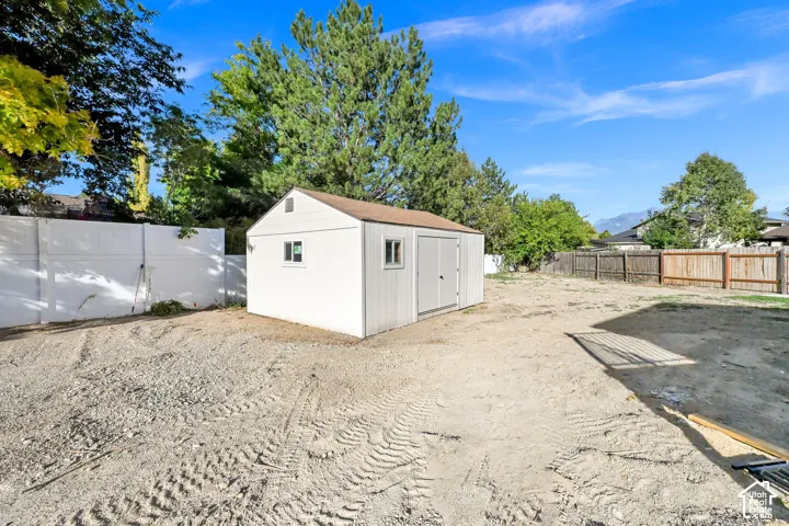Detached storage shed with a gable roof, paired windows, and a double-door entry