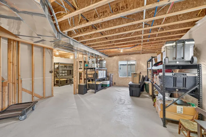 Unfinished basement with exposed wood joists, concrete flooring, and partial framing